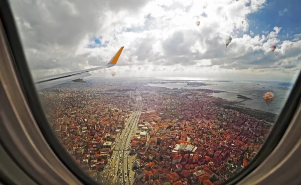 Aerial view through porthole of aircraft, flying over Istanbul city center with skyscraper buildings — Stock Photo, Image