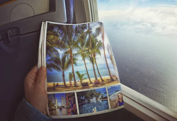 La mujer está sentada junto a la ventana en un avión con el cargador en las manos . — Foto de Stock