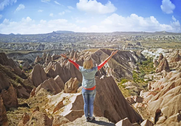Junge Frau auf einem Stein mit erhobenen Händen auf dem Gipfel des Berges — Stockfoto