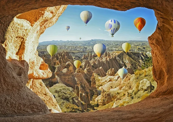 Kleurrijke hete lucht ballonnen vliegen over de vallei in Cappadocië — Stockfoto