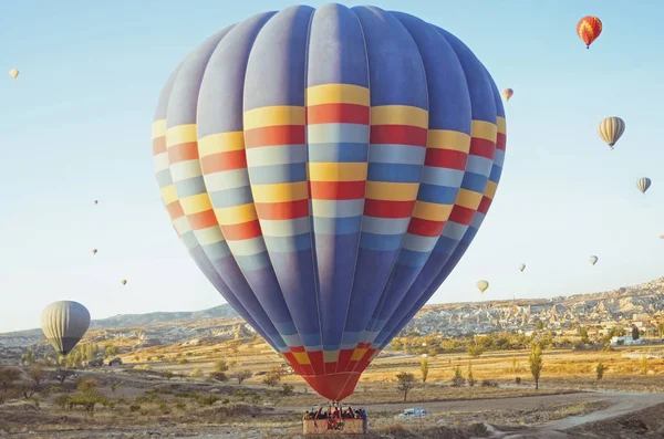 Colorido globo aerostático volando sobre el valle en Capadocia —  Fotos de Stock