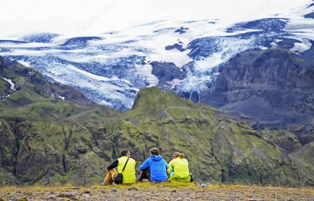 Group of hikers sitting on a ledge of a mountain, enjoying the beautiful view valley in Thorsmork