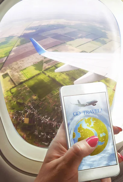 Vrouw reiziger zitten in de buurt van venster, houden van de werking van de telefoon aan boord van vliegtuig — Stockfoto