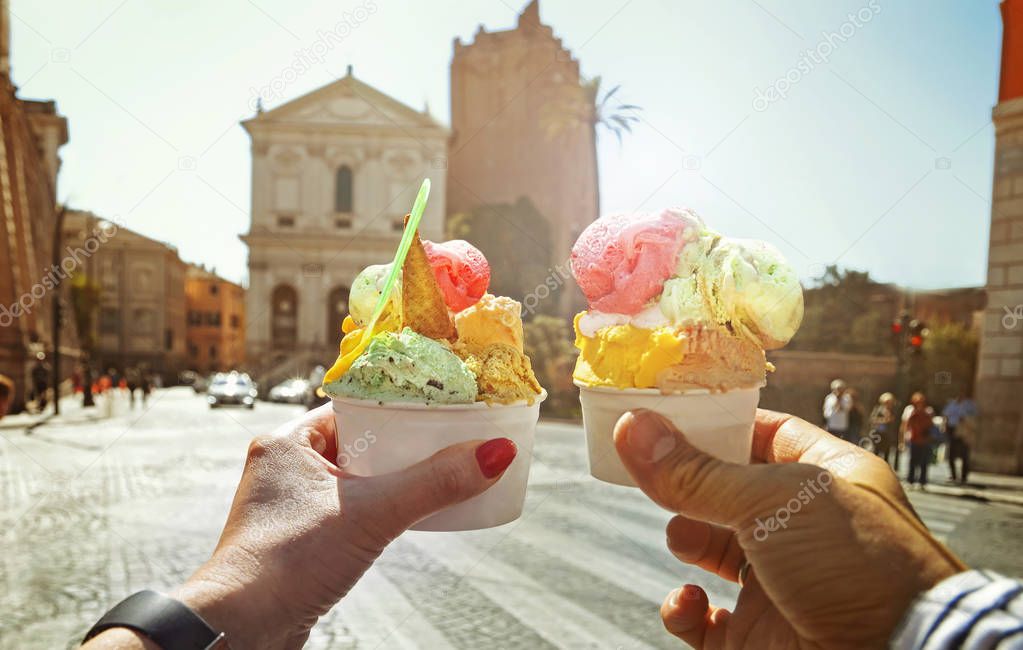 Couple with beautiful bright  sweet Italian ice-cream with different flavors  in the hands 