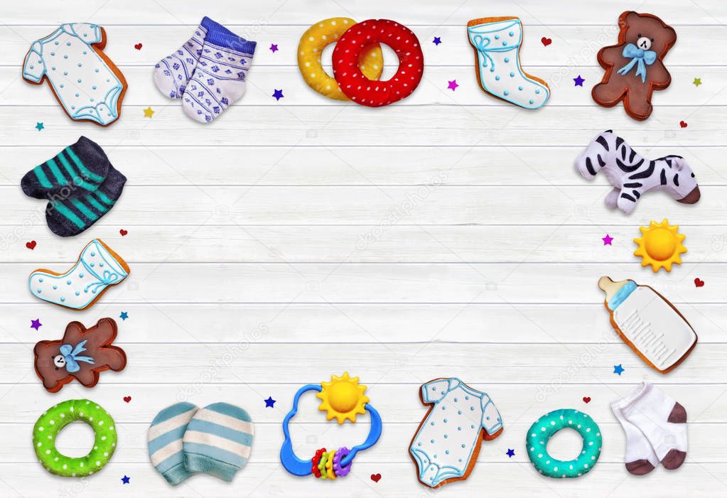 A composition for newborns on a wooden white background with  accessories : clothes,cookies, hearts , stars and toys .Concept art