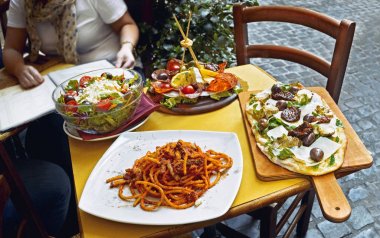 Bir yaz yemeği. Kimliği belirsiz kişi, Roma, İtalya, Trastevere bölgesinde açık restoranda geleneksel İtalyan yemek yeme. . Lezzetli ve otantik İtalyan mutfak