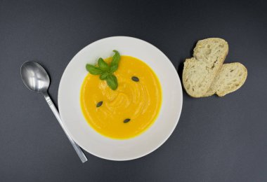 Siyah arkaplanlı taze kabak çorbası. 