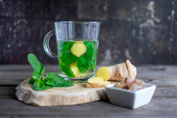 Té fresco con hojas de menta, bulbo de jengibre y azúcar de roca en tablero de madera —  Fotos de Stock