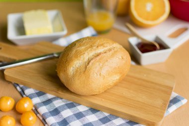 Gevrek buğday rulosu, reçel, tereyağı ve meyveli kahvaltı masası.