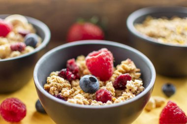 Güneş ışığında taze böğürtlenli lezzetli meyveli müsli. Bulanık arkaplanlı