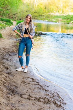 Genç kadın ıslak kumda çizimlerinin önünde rıhtımda duruyor. Konum: Almanya, Kuzey Ren Vestfalyası