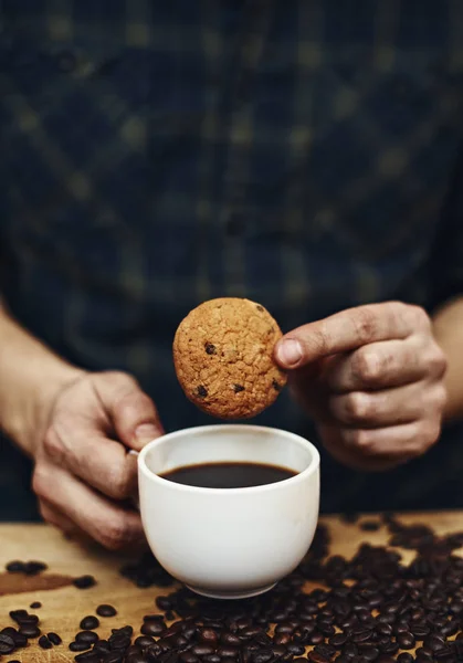 Mani maschili che tengono biscotto e tazza di caffè — Foto Stock