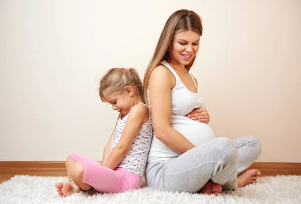 Szczęśliwy Ciąży Kobieta Siedzi Dywanie Jej Małą Córeczkę Dotykając Jej — Zdjęcie stockowe