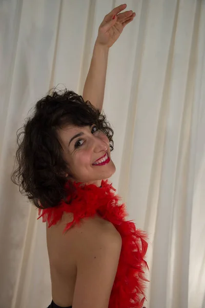 woman posing with dancing costume, with red feather boa