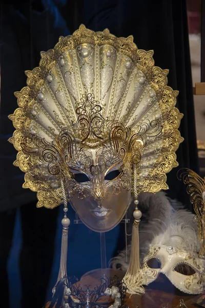 A large women\'s mask representing the sun. Handmade product of the Venetian carnival. Colored in gold on a white background. Venetian nobility concept. Product for sale in Venice, Italy.