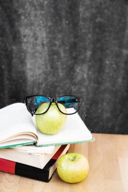 Kitap siyah tebeşir tahtası elma ve siyah gözlük ile tablo. 