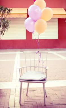 Sokak bir kafede modern sandalye pastel renk balonlar kutlama için açık havada ile dekore edilmiştir. Rahat windows arka planda panjurlar ile 