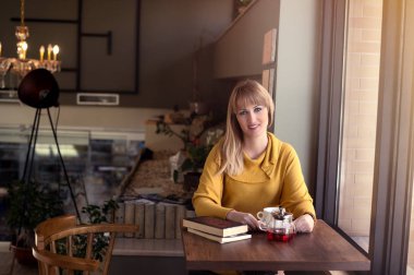 bir kafede çay readig bir kitap erken sabah içme ve çekici sarışın kadın
