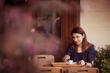 Genç kadın bir kafe havada kahve içme. Kahverengi tonlama
