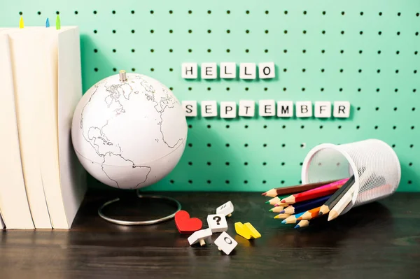 Voltar à escola fornece espaço de trabalho pastel com itens da moda, globo e letras de madeira em uma placa — Fotografia de Stock