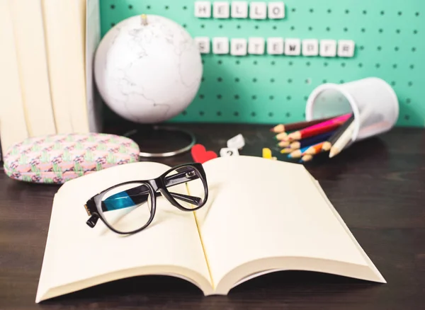 Voltar à escola fornece espaço de trabalho pastel com itens da moda, globo, óculos e livros e cartas de madeira em uma placa — Fotografia de Stock