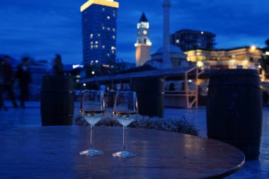 Arnavutluk 'un Tiran kentinde iki beyaz şarap kadehi, romantik bir akşam