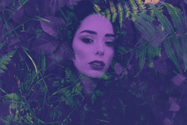 Çift pozlu kadın portresi. Saçında tropikal bitkiler var. Duotone