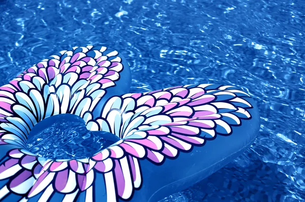 Mariposa inflada colorida flotando en una refrescante piscina azul — Foto de Stock