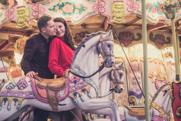 Ρομαντικό ζευγάρι λήψη μια στιγμή για να φιλήσει ενώ ιππασίας άλογα για καρουζέλ — Φωτογραφία Αρχείου