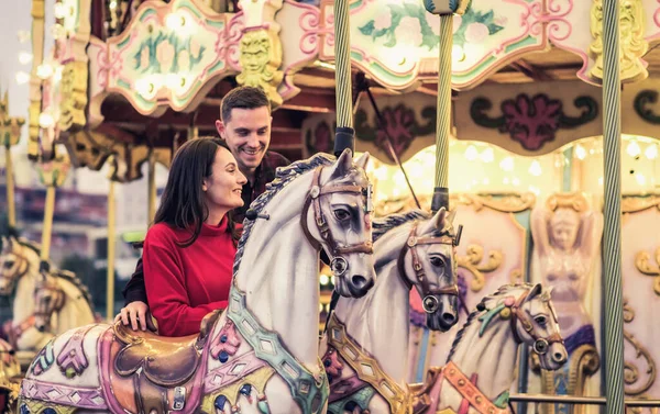 Romantyczna para biorąc chwilę się całować podczas jazdy konie na karuzeli — Zdjęcie stockowe
