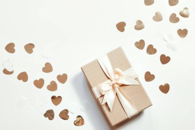 Beyaz zemin üzerinde altın konfetili mevcut kutu düz yatıyordu