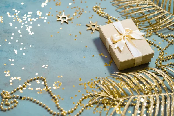 Cadeau Box bovenaanzicht op minimale achtergrond met gouden feestelijke palmbladeren — Stockfoto