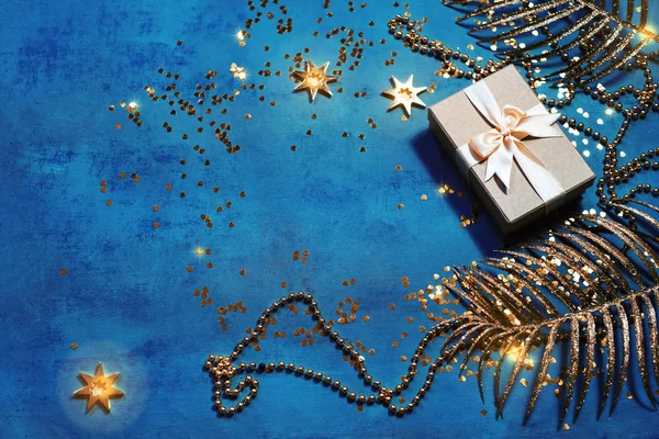 Cadeau Box bovenaanzicht op minimale achtergrond met gouden feestelijke palmbladeren — Stockfoto
