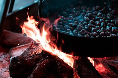 Kestaneler ateşte kavruluyor. Yaklaş.