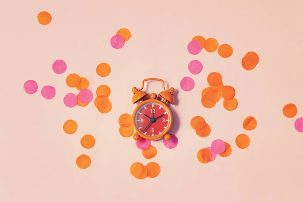 Reloj despertador vintage entre los confeti multicolores como concepto para celebrar —  Fotos de Stock