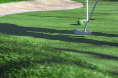 Mini golf sopası, top ve delik.
