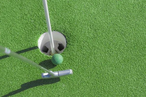 Mini clube de golfe, bola e buraco — Fotografia de Stock