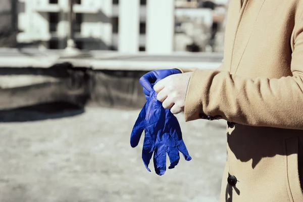 Mann zieht medizinische Handschuhe zum Schutz vor Coronavirus an — Stockfoto