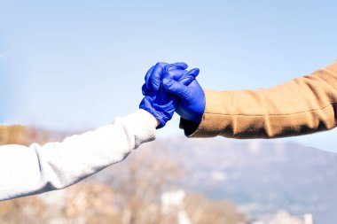 Coronavirus 'tan korunan tıbbi eldiven takan adam ve çocuk el ele tutuşuyor.