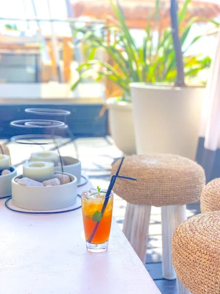 Ледяной чай с лимоном и черной соломой на натуральном белом столе в летнем баре на пляже — стоковое фото