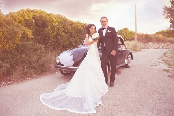 Novomanželům, mladý pár a Epoque auto — Stock fotografie