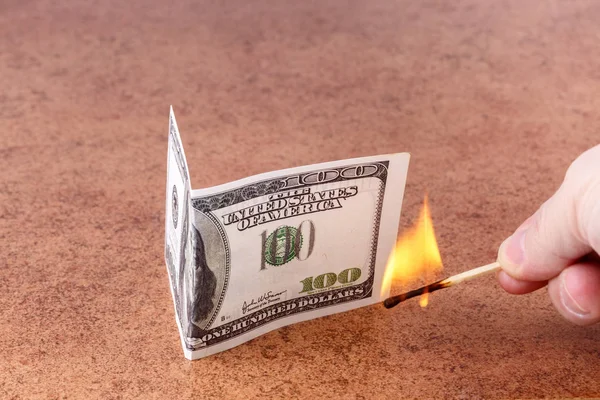 Burning match in hand, sets fire to $ 100 bills Royalty Free Stock Photos