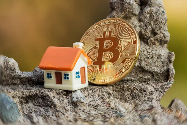 Speelgoed huis op een achtergrond van munten bitcoin — Stockfoto