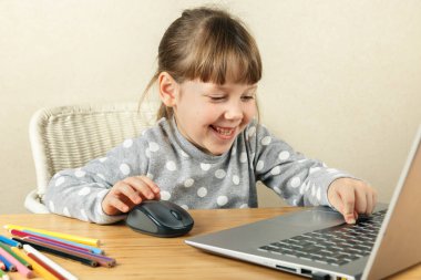 The child presses the space bar on the computer and laughs clipart