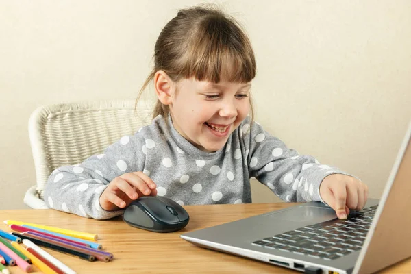 Das Kind drückt die Leertaste am Computer und lacht Stockbild