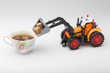 Oyuncak traktör şekerli bir fincan kahve yükler