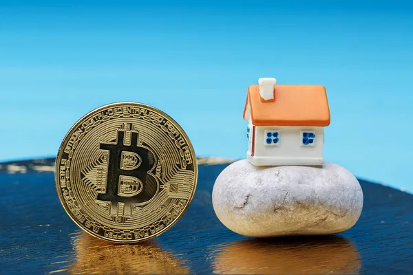 Haus auf dem Felsen und Bitcoin lizenzfreie Stockfotos
