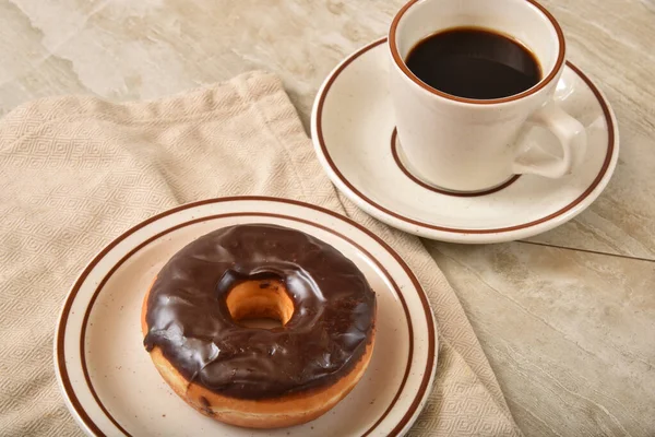 Choklad frostad munk med kaffe — Stockfoto