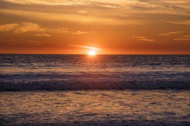 Pasifik Okyanusu üzerinde parlak turuncu gün batımı