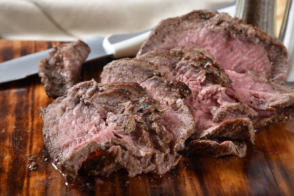 Closeup of a sliced top sirloin beef roast on a cutting board
